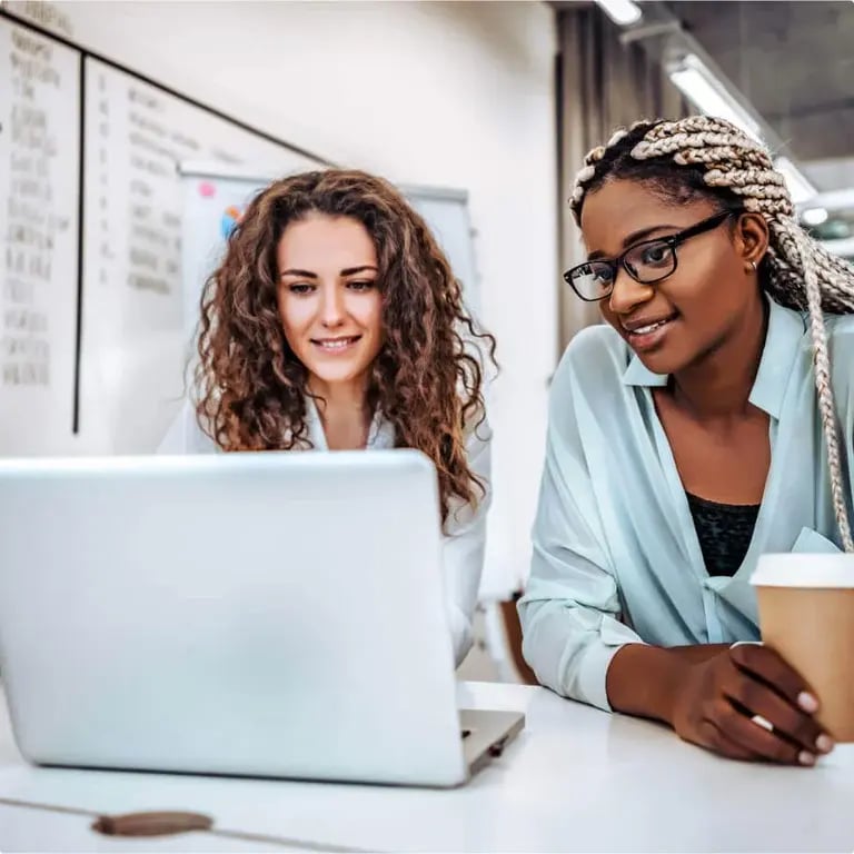 two women sharing a laptop